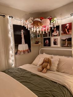 a teddy bear sitting on top of a bed in a room with pictures and lights