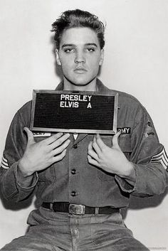 a man holding up a sign with the words friskley elvis a on it