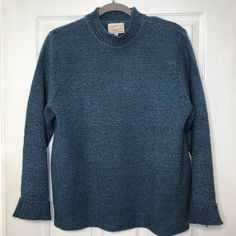 a blue sweater hanging on a white door