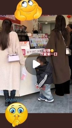 two women and a child are standing in front of a food stand with emoticions on it