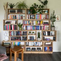 a living room filled with lots of books and plants