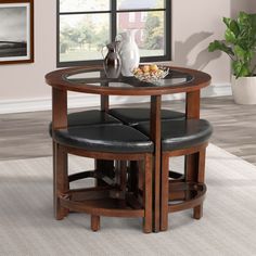 a table with two stools and a vase on it in front of a window