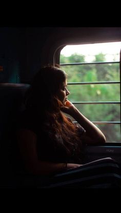 a woman sitting on a train looking out the window