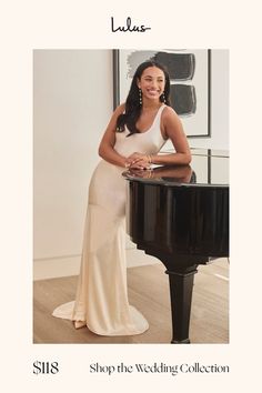 a woman in a white dress standing next to a black piano with the words shop the wedding collection on it