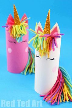 two cups with unicorns made out of paper and colored yarn, one is pink the other is yellow