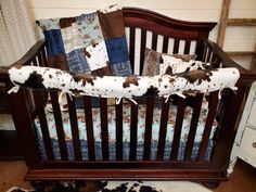 a baby crib with a cow print blanket on it