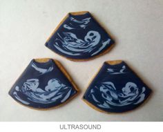 three decorated cookies sitting on top of a table