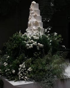 a wedding cake with white flowers and greenery