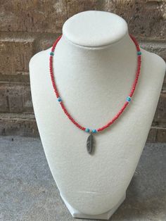 Feather choker boho vibe with red primary colors and turquoise accents. Red Bohemian Choker With Colorful Beads, Bohemian Red Choker With Colorful Beads, Red Hippie Jewelry With Colorful Beads, Handmade Red Hippie Beaded Necklace, Hippie Style Red Jewelry With Colorful Beads, Bohemian Red Beaded Choker, Hippie Red Necklaces For Festival, Handmade Red Choker For Beach, Adjustable Red Hippie Necklace