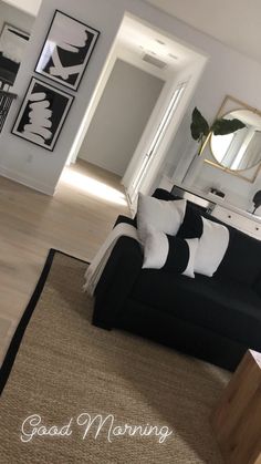 a living room filled with black and white furniture next to a mirror on the wall