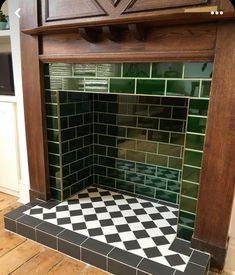 a black and white checkered floor next to a fireplace with green tiles on it