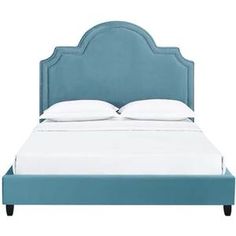 a blue bed with white sheets and pillows on top of the headboard is shown