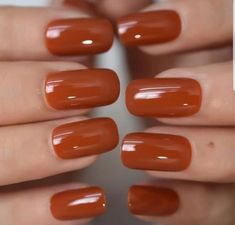 a woman's hands with orange nail polish