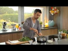 a man is cooking in the kitchen with vegetables on the counter and other ingredients around him