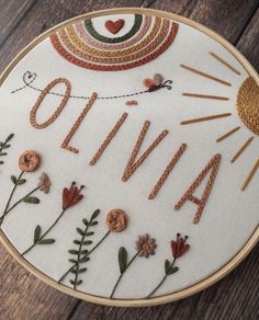 embroidered name art with flowers and sunbursts