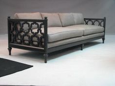 a black and white couch sitting on top of a rug next to a gray wall