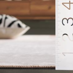 a close up of a ruler on a bed with a zebra pillow in the background