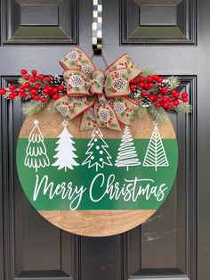 a merry christmas door hanger on a front door with red berries and evergreens