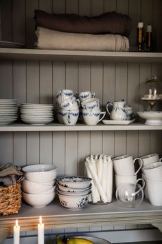 the shelves are filled with dishes and cups