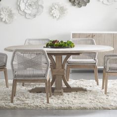 a dining room table with chairs and a bowl of flowers on top of the table