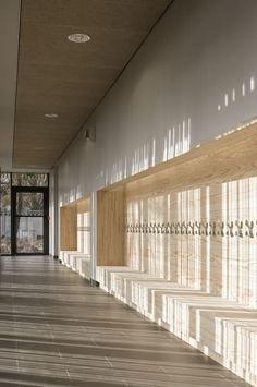 an empty hallway with wooden paneling and white walls