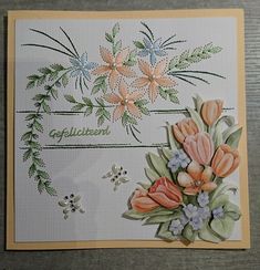 a greeting card with flowers and leaves on the front, in pastel orange tones