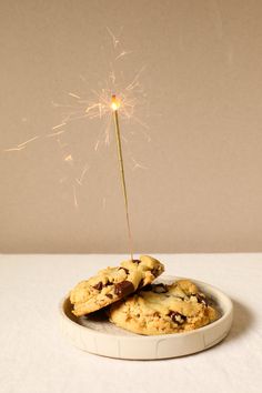 two cookies and a sparkler on a plate