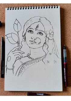 a drawing of a woman with a flower in her hand and two pens next to it