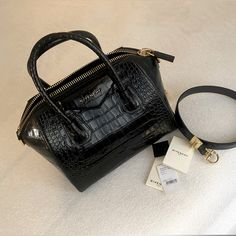 Featuring The Signature Trapezoidal Silhouette And Pentagonal Givenchy Patch, This Handbag Is A Part Of The Antigona Collection And Is Crafted From Glossy Crocodile-Embossed Leather. It Is Fitted With A Top Carry Handle And Detachable Shoulder Strap For Versatile Wear. Condition:Excellent Accessories: Includes Removable Leather Strap. Detailed Pictures And Provide An Overall Rating To Help In Describing The Condition Of This Item. Designer Givenchy Made In Italy Size (In) 11 (Width) X 9.5 (Heigh Luxury Evening Bag With Crocodile Pattern, Designer Shoulder Bag With Crocodile Pattern For Formal Occasions, Designer Crocodile Pattern Shoulder Bag For Evening, Luxury Crocodile Pattern Shoulder Bag, Elegant Evening Shoulder Bag With Crocodile Pattern, Designer Crocodile Pattern Satchel For Formal Occasions, Luxury Crocodile Pattern Shoulder Bag For Formal Occasions, Luxury Crocodile Pattern Shoulder Bag For Formal Events, Luxury Crocodile Pattern Shoulder Bag For Office