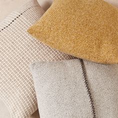 three different colored pillows sitting next to each other