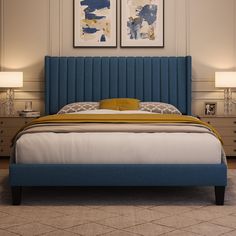 a bed with blue headboard and two pictures on the wall above it in a bedroom