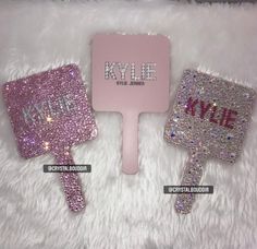 two pink and silver hairbrushes sitting next to each other on a white fur surface