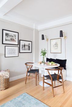 a white table and chairs in a room with pictures on the wall above it, along with other furniture