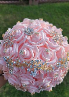 a bridal bouquet in the shape of a rose with jewels on it is being held by someone's hand