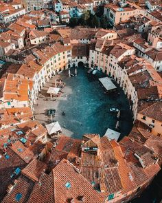 an aerial view of a city with lots of red roofs and brown tile on the buildings