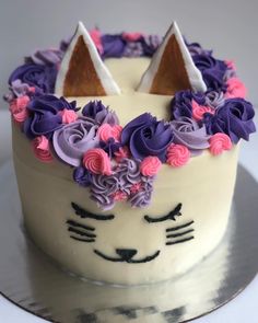 a cat cake decorated with purple and pink flowers