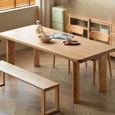 a wooden table with two benches in front of it and a vase on the other side