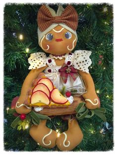 a christmas tree ornament with an apple slice in the shape of a doll