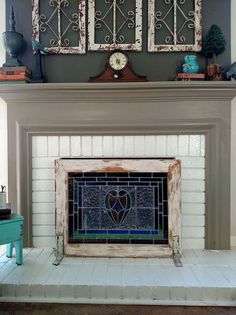 a fireplace with two framed pictures above it and a clock on the mantel top