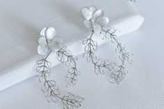 The Ollie earrings will transport you to the sun-drenched isles of ancient Greece, surrounding you in an aura of elegance and grace. Elevate your bridal look with this exquisite accessory that beautifully complements any wedding dress. DETAILS ❁Handcrafted dip resin blooms with fresh water pearl details. ❁Features a curvy leafs arrangement for a delicate, ethereal look. ❁Feather-light design ensure effortless on-ear experience. ❁Designed and handmade in Canada. Worldwide shipping. ❁Beautifully g Dainty Silver Chandelier Earrings For Wedding, Handmade Flower Chandelier Earrings For Wedding, Dainty Silver Flower Earrings For Wedding, Elegant Leaf-shaped Wedding Jewelry, Handmade Leaf-shaped Wedding Earrings, Handmade Leaf-shaped Earrings For Weddings, Handmade Leaf-shaped Wedding Jewelry, Handmade Silver Flower Bridal Earrings, Leaf-shaped Wedding Jewelry With Matching Earrings