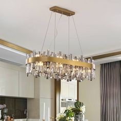 a chandelier hanging from the ceiling in a modern kitchen with marble counter tops