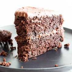 there is a piece of chocolate cake with frosting on the top and one slice missing