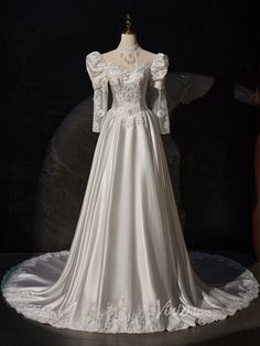 a white wedding dress with long sleeves on display