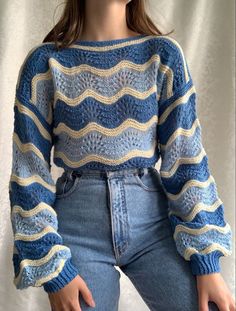 a woman is wearing a blue and yellow striped sweater with her hands in her pockets