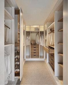 a walk in closet with white walls and drawers