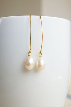 Long Gold Freshwater Pearl Drop Earrings, No. EGH056 :*About This Piece*: ♦︎ These matching, lustrous creamy freshwater pearl teardrops have hints of pink and are truly classy. They are hung on long gold plated sterling silver earrings. Due to the natural formation of these pearls, there will be slight variations in the color and shape of the pearls. ♦︎ Length - 1.7 in (43 mm) ♦︎ Width - .3 in (8 mm) ♦︎ All items from my shop are packaged in padded cardboard jewelry boxes. Custom gifting options Classic Pearl White Teardrop (pear Shaped) Earrings, Classic Pearl Teardrop Earrings, Classic Pearl Teardrop Dangle Earrings, Classic Pearl White Pear-shaped Teardrop Earrings, Elegant Cream Pearl Earrings For Gifts, Elegant Everyday Cream Jewelry, Classic Pearl White Teardrop Pearl Earrings, Classic Pearl White Teardrop Earrings, Graceful Pearl Teardrop Earrings