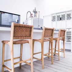 three wooden stools sitting in front of a kitchen counter