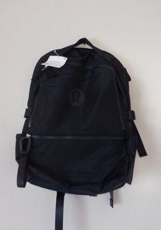 Lululemon New Crew Backpack 100% authentic New with Tags $98 Fabric is repellent exterior zippered pocket to secure your valuables  side pockets for quick access to water bottle and small items interior padded pocket fits a 15" loptop  interior pockets hold the essentials trolley-compatible sleeve dimensions 11.4" x 7.3" x 16.5" Volume 22L Lulu Bookbag, Black Lulu Backpack, Lululemon New Crew Backpack 22l, Lululemon Backpack Black, Lululemon Sporty Standard Backpack, Lululemon On-the-go Bag With Adjustable Strap, Lululemon Backpack, School Bag, Small Items