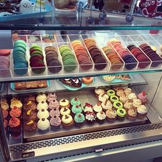 a display case filled with lots of different types of cupcakes and pastries