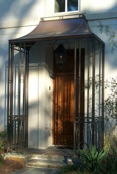 the front door of a house with an iron fence around it